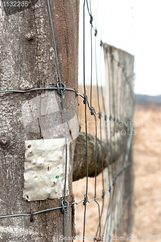 Image of Wooden fence with metal plate against blurry background