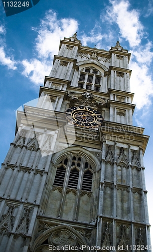Image of Clock tower against blue sky with clock in the middle