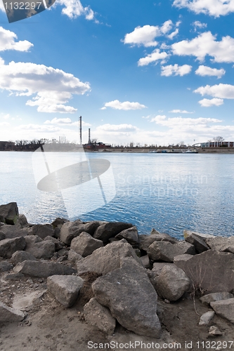 Image of Bank of a river with powerplant and blue sky