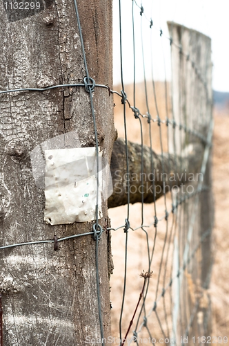 Image of Wooden fence with metal plate against blurry background