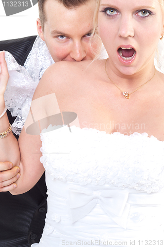 Image of Groom bite's shoulder of the bride