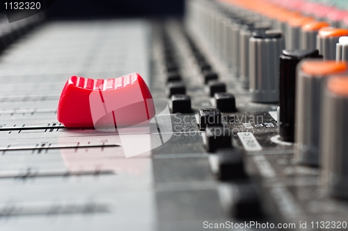 Image of Part of an audio sound mixer with buttons and a slider