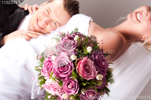 Image of young couple in wedding wear with bouquet of roses