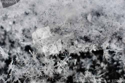 Image of Ice cristals falling with black background macro shot