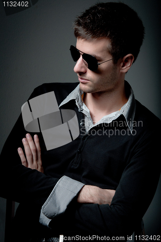Image of Young man looking in the opposite side wearing sunglasses