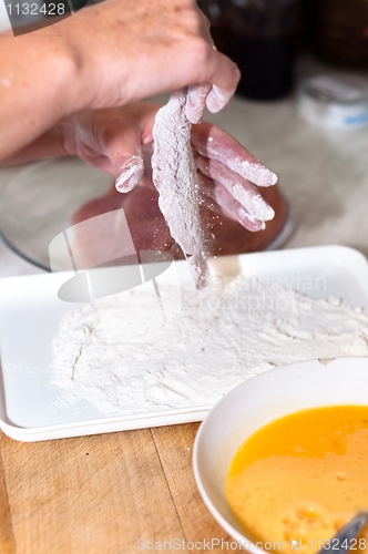 Image of Fresh meat with flour on in the hands of a cook with blurry back