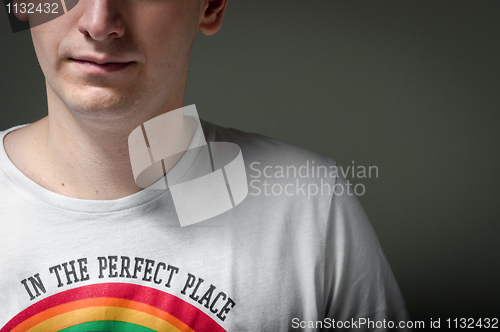 Image of Close-up of a man with rainbow on shirt and dark background