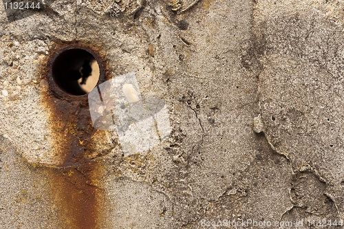 Image of Rusty hole in concrete wall