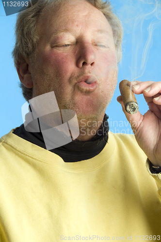 Image of handsome middle age man smoking expensive cigar