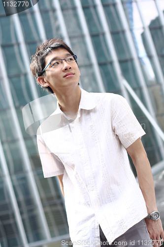 Image of Young businessman looking to good future on modern building back