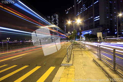 Image of blurred bus light trails in downtown night-scape 