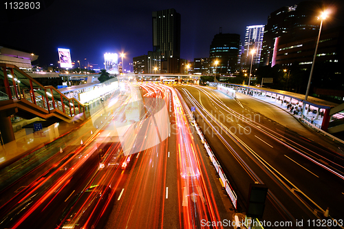 Image of blurred bus light trails in downtown night-scape 