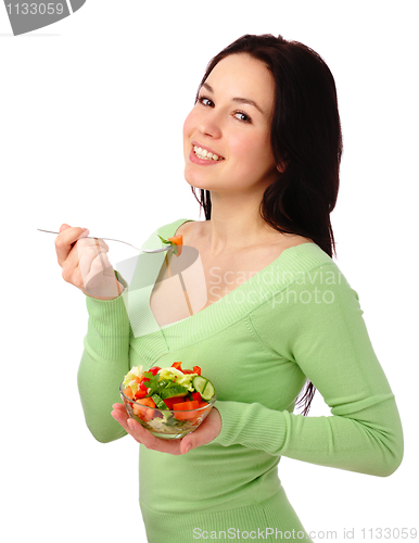 Image of Young attractive woman eats vegetable salad