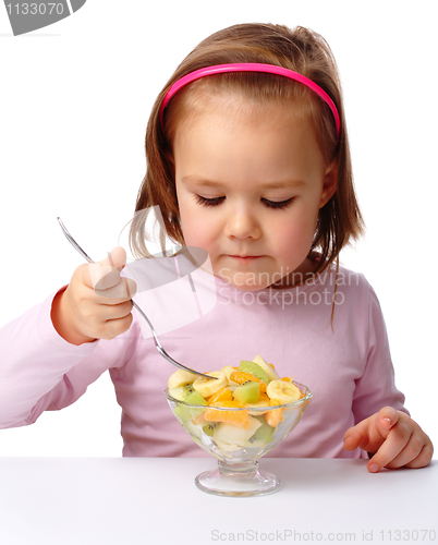 Image of Little girl eats fruit salad