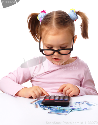 Image of Little girl plays with money