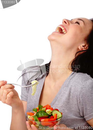 Image of Young attractive woman eats vegetable salad