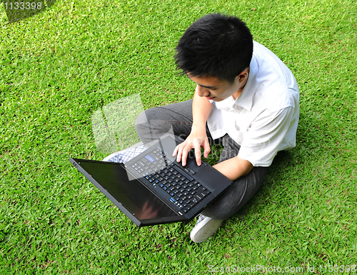 Image of asian man using computer outdoor