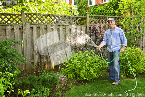 Image of Man watering garden