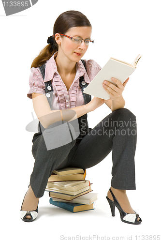 Image of young girl with glasses reading a book