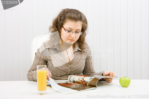 Image of chubby girl reads a fashion magazine