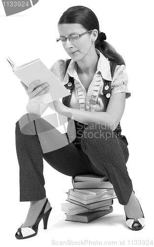 Image of young girl with glasses reading a book