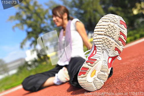 Image of woman doing stretching exercise in sport field