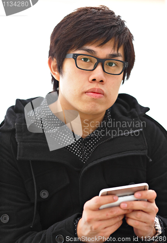 Image of asian man sms on cell phone