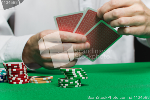Image of poker chips and the player's hand with the cards