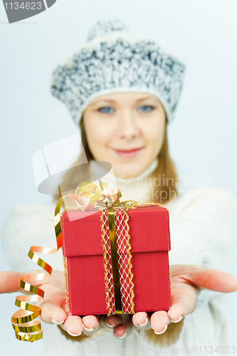 Image of girl in winter hat gives gift box