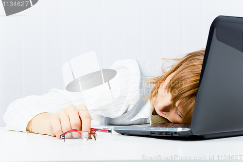Image of worker, asleep on a laptop