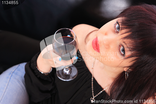 Image of A young woman relaxes at home on the sofa