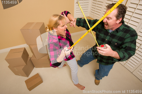 Image of Couple Having Fun Sword Fight with Tape Measures