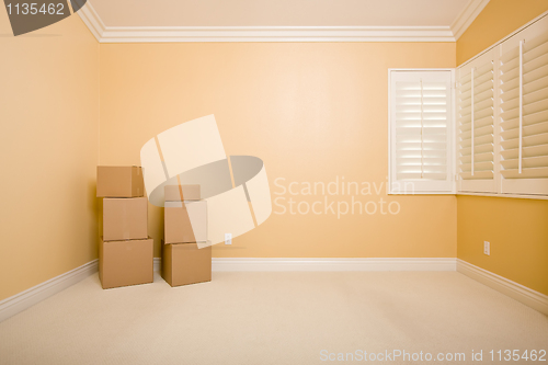 Image of Moving Boxes in Empty Room with Copy Space on Wall