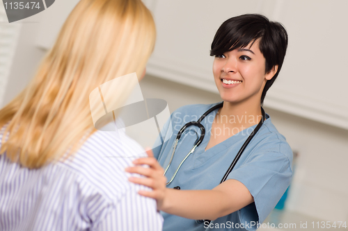 Image of Attractive Multi-ethnic Young Female Doctor Talking with Patient