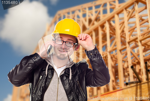 Image of Young Cunstruction Worker on Cell Phone In Front of House