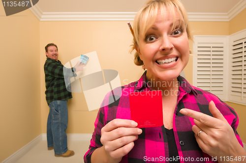 Image of Couple Comparing Paint Colors in Empty Room