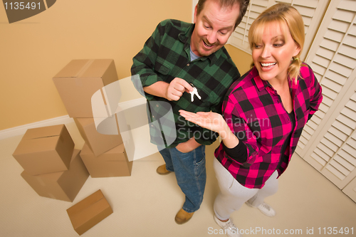 Image of Goofy Excited Man Handing Keys to Smiling Wife