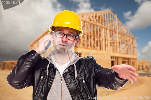 Image of Young Cunstruction Worker on Cell Phone In Front of House