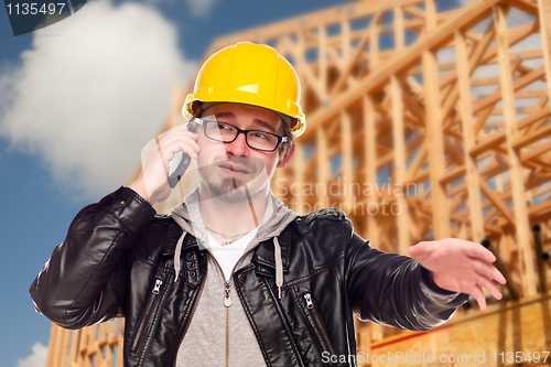 Image of Young Cunstruction Worker on Cell Phone In Front of House