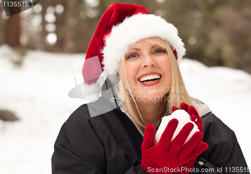 Image of Attractive Santa Hat Wearing Blond Woman Having Fun in Snow