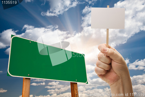 Image of Blank Green Road Sign and Man Holding Poster on Stick 