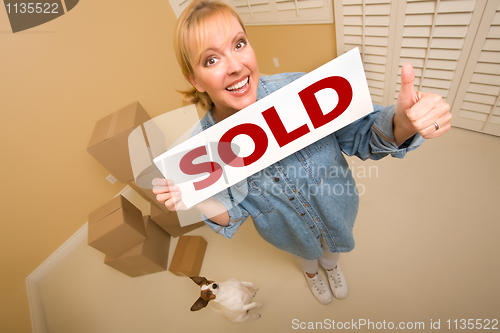 Image of Woman and Doggy with Sold Sign Near Moving Boxes