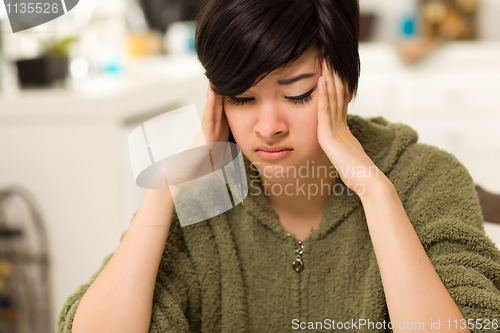 Image of Multi-ethnic Young Woman Rubbing Her Temples