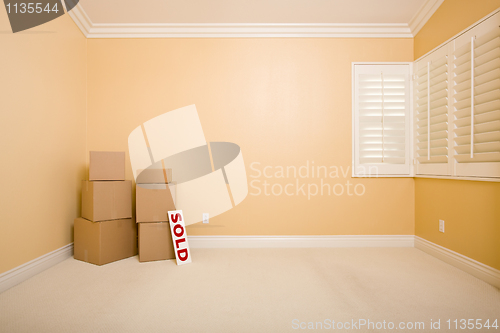 Image of Moving Boxes and Sold Real Estate Sign on Floor