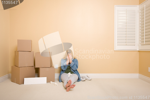 Image of Upset Woman on Floor Next to Boxes and Blank Sign