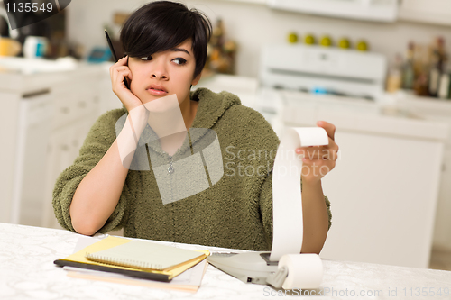 Image of Multi-ethnic Young Woman Agonizing Over Financial Calculations