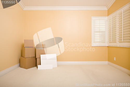 Image of Moving Boxes and Blank Signs on Floor in Empty Room 