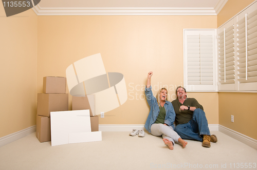 Image of Couple on Floor Near Boxes and Blank Signs