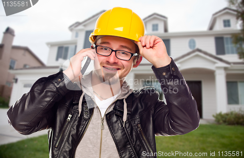 Image of Contractor Wearing Hard Hat on Phone In Front of House