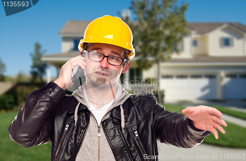 Image of Contractor Wearing Hard Hat on Phone In Front of House